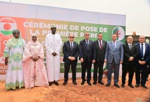 Niamey, 24 mars 2026 – Le Niger franchit une nouvelle étape dans le renforcement de ses capacités énergétiques. Le Premier ministre nigérien, Ali Mahamane Lamine Zeine, et son homologue algérien ont procédé ce matin à la pose de la première pierre de la centrale électrique « Solidarité », un projet énergétique d’une capacité de 40 mégawatts, situé dans la zone de Goro Banda à Niamey. Cette infrastructure s’inscrit dans le cadre du renforcement de la coopération entre le Niger et l’Algérie. Un projet énergétique pour renforcer l’électricité au NigerLa future centrale électrique devrait contribuer à améliorer l’approvisionnement en électricité dans la capitale et ses environs. En effet, le Niger fait face à une demande énergétique en constante augmentation liée à la croissance démographique, au développement urbain et aux activités économiques.Ainsi, la construction de cette centrale vise à renforcer le réseau électrique national et à réduire les difficultés d’accès à l’électricité pour les populations et les entreprises. Ce projet énergétique est considéré comme une infrastructure importante pour soutenir le développement économique et industriel du pays. Une coopération énergétique entre Niamey et AlgerLa pose de la première pierre de la centrale « Solidarité » s’inscrit dans le cadre de la coopération entre le Niger et l’Algérie, à travers les mécanismes bilatéraux qui unissent les deux pays. Ce projet est le résultat de plusieurs échanges et engagements entre les autorités nigériennes et algériennes visant à développer des projets communs dans les domaines stratégiques.Le secteur de l’énergie apparaît aujourd’hui comme l’un des axes majeurs de la coopération entre les deux pays, aux côtés des infrastructures, des télécommunications et du secteur pétrolier. Un projet inscrit dans une vision de souveraineté énergétiqueAu Niger, les autorités mettent en avant la nécessité de renforcer la souveraineté énergétique du pays en développant la production locale d’électricité et en diversifiant les sources d’énergie. La construction de nouvelles centrales électriques fait partie de cette stratégie visant à améliorer l’accès à l’électricité et à soutenir la croissance économique.La centrale « Solidarité » vient ainsi s’ajouter aux projets énergétiques en cours dans le pays et devrait contribuer à améliorer la stabilité du réseau électrique national. Un symbole du partenariat stratégique Niger–AlgérieCette centrale incarne aussi le symbole du partenariat entre le Niger et l’Algérie. La coopération entre les deux pays se renforce progressivement dans plusieurs secteurs : énergie, infrastructures, télécommunications et formation.Cette nouvelle infrastructure énergétique illustre la volonté des deux États de développer des projets concrets et structurants dans le cadre de leur coopération bilatérale.En définitive, la construction de la centrale électrique « Solidarité » marque une étape décisive dans les relations entre Niamey et Alger, tout en représentant un projet majeur pour améliorer l’accès à l’électricité au Niger.