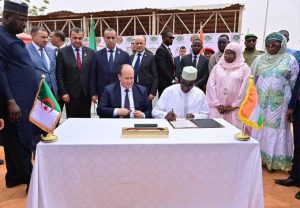 Niamey, 24 mars 2026 – Le Niger franchit une nouvelle étape dans le renforcement de ses capacités énergétiques. Le Premier ministre nigérien, Ali Mahamane Lamine Zeine, et son homologue algérien ont procédé ce matin à la pose de la première pierre de la centrale électrique « Solidarité », un projet énergétique d’une capacité de 40 mégawatts, situé dans la zone de Goro Banda à Niamey. Cette infrastructure s’inscrit dans le cadre du renforcement de la coopération entre le Niger et l’Algérie. Un projet énergétique pour renforcer l’électricité au NigerLa future centrale électrique devrait contribuer à améliorer l’approvisionnement en électricité dans la capitale et ses environs. En effet, le Niger fait face à une demande énergétique en constante augmentation liée à la croissance démographique, au développement urbain et aux activités économiques.Ainsi, la construction de cette centrale vise à renforcer le réseau électrique national et à réduire les difficultés d’accès à l’électricité pour les populations et les entreprises. Ce projet énergétique est considéré comme une infrastructure importante pour soutenir le développement économique et industriel du pays. Une coopération énergétique entre Niamey et AlgerLa pose de la première pierre de la centrale « Solidarité » s’inscrit dans le cadre de la coopération entre le Niger et l’Algérie, à travers les mécanismes bilatéraux qui unissent les deux pays. Ce projet est le résultat de plusieurs échanges et engagements entre les autorités nigériennes et algériennes visant à développer des projets communs dans les domaines stratégiques.Le secteur de l’énergie apparaît aujourd’hui comme l’un des axes majeurs de la coopération entre les deux pays, aux côtés des infrastructures, des télécommunications et du secteur pétrolier. Un projet inscrit dans une vision de souveraineté énergétiqueAu Niger, les autorités mettent en avant la nécessité de renforcer la souveraineté énergétique du pays en développant la production locale d’électricité et en diversifiant les sources d’énergie. La construction de nouvelles centrales électriques fait partie de cette stratégie visant à améliorer l’accès à l’électricité et à soutenir la croissance économique.La centrale « Solidarité » vient ainsi s’ajouter aux projets énergétiques en cours dans le pays et devrait contribuer à améliorer la stabilité du réseau électrique national. Un symbole du partenariat stratégique Niger–AlgérieCette centrale incarne aussi le symbole du partenariat entre le Niger et l’Algérie. La coopération entre les deux pays se renforce progressivement dans plusieurs secteurs : énergie, infrastructures, télécommunications et formation.Cette nouvelle infrastructure énergétique illustre la volonté des deux États de développer des projets concrets et structurants dans le cadre de leur coopération bilatérale.En définitive, la construction de la centrale électrique « Solidarité » marque une étape décisive dans les relations entre Niamey et Alger, tout en représentant un projet majeur pour améliorer l’accès à l’électricité au Niger.